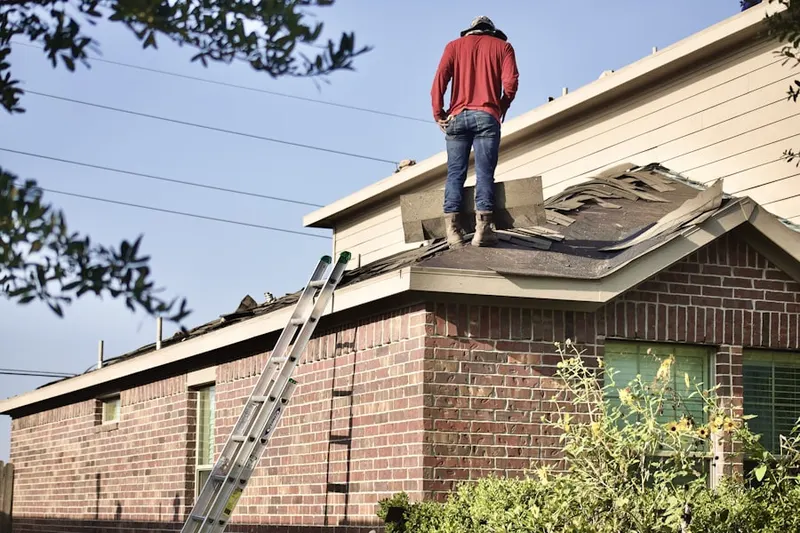 Professional roofer working on a residential roof in Bowers
